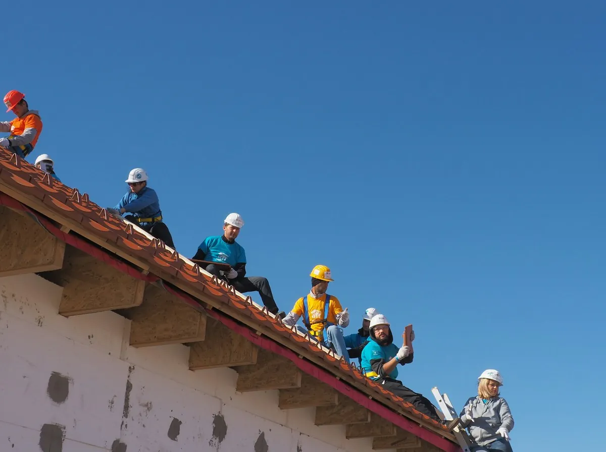 Roof Replacement in Rialto — a crew in hard hats sitting on a tile roof during a repair